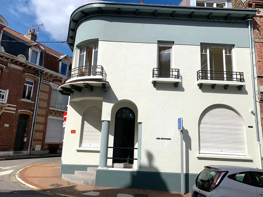 Light-coloured town house with its windows and roller shutters